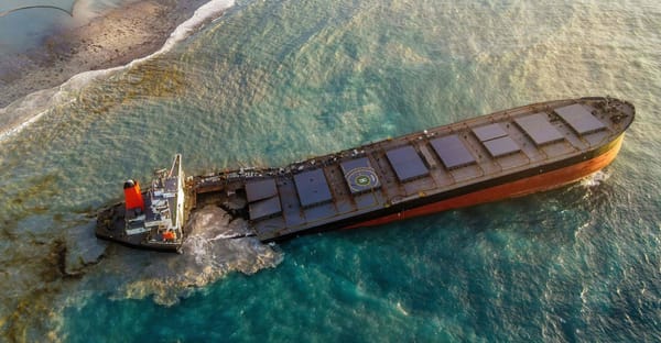 A sunken oil tanker on the shores of a beach.